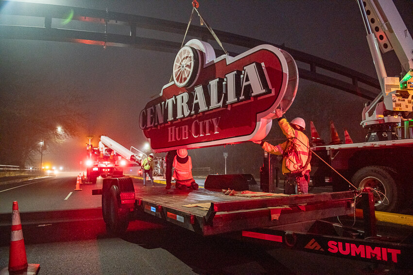 A crew hoists a new, lighted sign to attach to an arch over Harrison Avenue in Centralia on Monday night. The workers from New Image Creative Sign Inc. were contracted by the city to complete the work, which was mostly finished on Tuesday night.