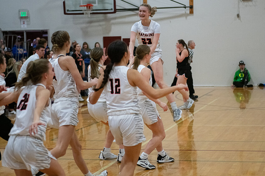 Keira O'Neill jumps as her teammates storm the court after Napavine's District Championship win over Rainier on Feb. 17. in Chehalis.