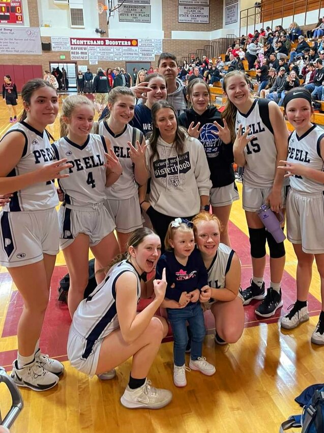 The Pe Ell girls basketball team poses for a photo after clinching a state tournament bid with a 27-21 win over Willapa Valley in the 1B District 4 third-place game at Montesano on Feb. 17
