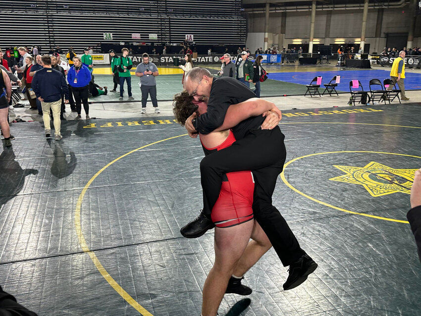 Yelm's Jonah Smith celebrates with head coach Gaylord Strand after he defeated Ferndale's Wyatt Strait in WIAA's 3A 285-pound state championship match on Saturday, Feb. 17, at Mat Classic XXXV.