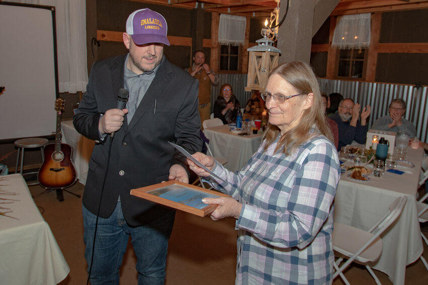 Onalaska Alliance President Duane Blair honors the organizations outgoing treasurer, Carol Heifner, during the Alliance's fundraising banquet inside The Mason Jar Gathering Barn on Saturday, Feb. 24.