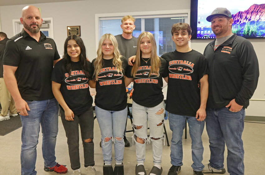 Centralia High School wrestling head coach Scott Phillips, far right, and wrestling assistant coach Andrew Huerta, far left, stand with Centralia wrestlers Luna Martinez-Arevalo, Eva Reinitz, Ramona Reinitz and Antonio Campos and Centralia golfer Voss Wasson, behind, at the Centralia School District Office on Wednesday, Feb. 28.