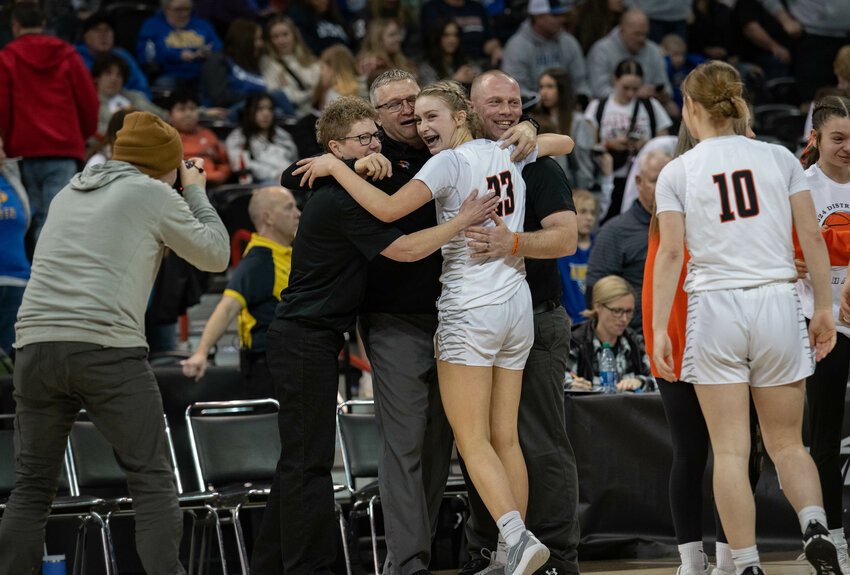 Keira O'Neill hugs coaches Josh Fay, Shane Shutz, and Kim Roberts after Napavine&rsquo;s 2B State semifinal win over Adna on Mar. 1 at the Spokane Arena.