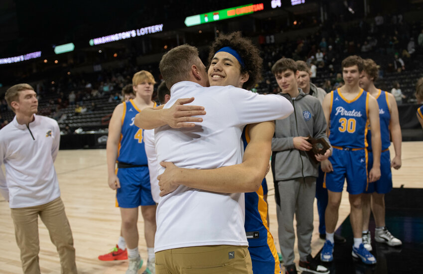 Pirate coach Luke Salme hugs Jens Neilson after Adna placed fourth in the state 2B tournament on March 2 at the Spokane Arena.