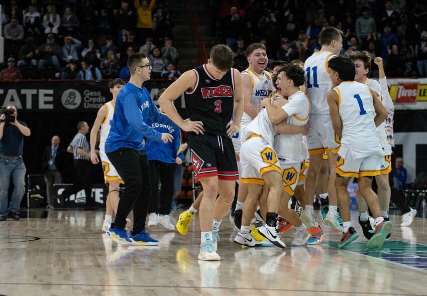 Wellpinit players celebrate as Easton Kolb walks off the court after Mossyrock's 1B state championship game versus Wellpinit on March 2 at the Spokane Arena.