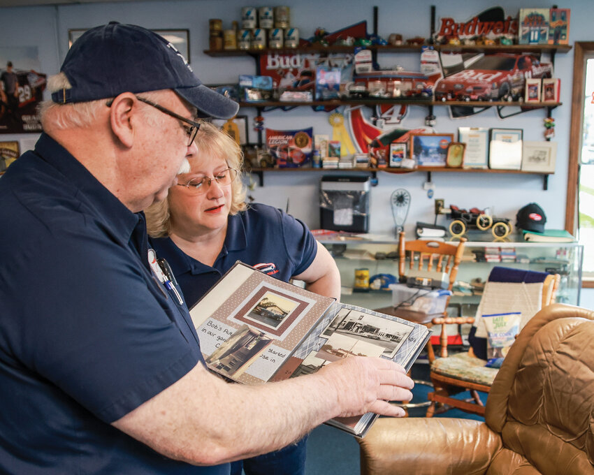 Bob Ford and his wife, Priscilla, look through a photo scrapbook dedicated to the last 30 years of Bob’s Automotive in Ridgefield.