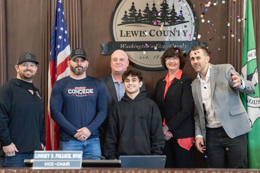 Lewis County Commissioner Sean Swope throws confetti during a photo with Antonio Campos, wrestling state champion, during a meeting on Tuesday, March 5.