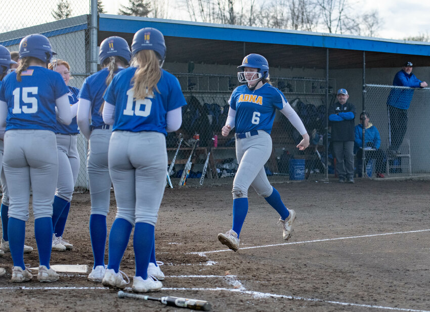 Pirate players surround home plate as Kendall Humphrey rounds the bases after a home run during Adna&rsquo;s 2-0 win over Rochester on March 13.