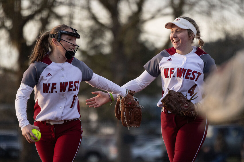 W.F. West's Lena Fragner (4), right, and W.F. West's Taylor Tobin (10) celebrate winning against Kelso at Recreation Park on Thursday, March 14. W.F. West defeated Kelso 12-4.