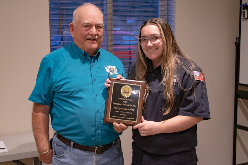 Lewis County Fire District 3 volunteer firefighter Morgan Browning smiles while holding her National Grange 2023 Firefighter/EMT of the Year award alongside Mossyrock Grange President Darell Myers at the District 3 fire station in Mossyrock on Tuesday, March 12.