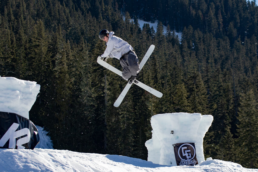Evan Attaway crosses his skis and grabs one of his ski tips while twisting through the air on Saturday, March 16, at White Pass Ski Area's 2024 Castle Jam freestyle trick competition.