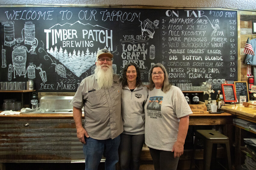 Jim and Laurie Judd hug their daughter, Jocelyn, during Timber Patch Brewing's fourth anniversary weekend on Saturday, March 16, when the brewery's first canned beer, the Full Recovery IPA, was also released.