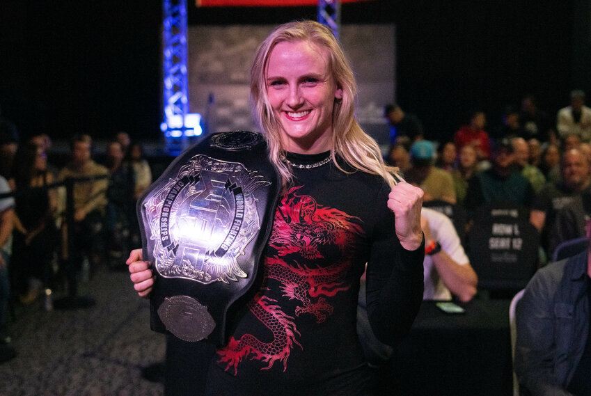 Mixed martial arts fighter and W.F. West High School graduate Kayla Weed smiles after receiving the women's World Fighting Championships (WFC) championship belt after an opponent forfeited during WFC 167 at Little Creek Casino in Shelton on Saturday, March 23. Though her opponent dropped out before the fight, Weed was still able to come out and accept the WFC 145-pound title on Saturday. Weed was one of the first members and founders of the girls wrestling team at W.F. West.