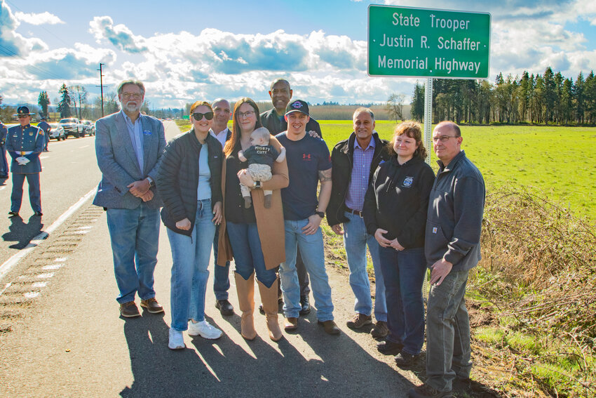 Family members of fallen Washington State Patrol Trooper (WSP) Justin Schaffer pose with 20th Distict state Rep. Ed Orcutt, back left, 20th District state Rep. Peter Abbarno, back center, WSP Chief John Batiste, back right, and 19th District state Sen. Jeff Wilson, third from right, after unveiling the sign marking the stretch of state Route 6 between Adna and Chehalis dedicated in Schaffer's memory on Sunday, March 24.