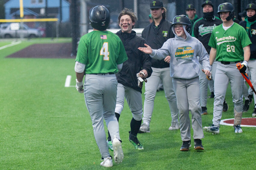 Teammates greet Peyton Davis after an inside-the-park home run during Tumwater&rsquo;s game against Centralia at Centralia College on Thursday, March 28.