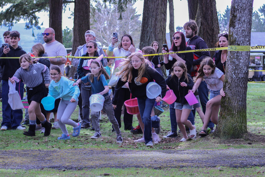 Children race from under the caution tape to collect eggs during We Love Rainier WA's Easter Egg Hunt on March 30.