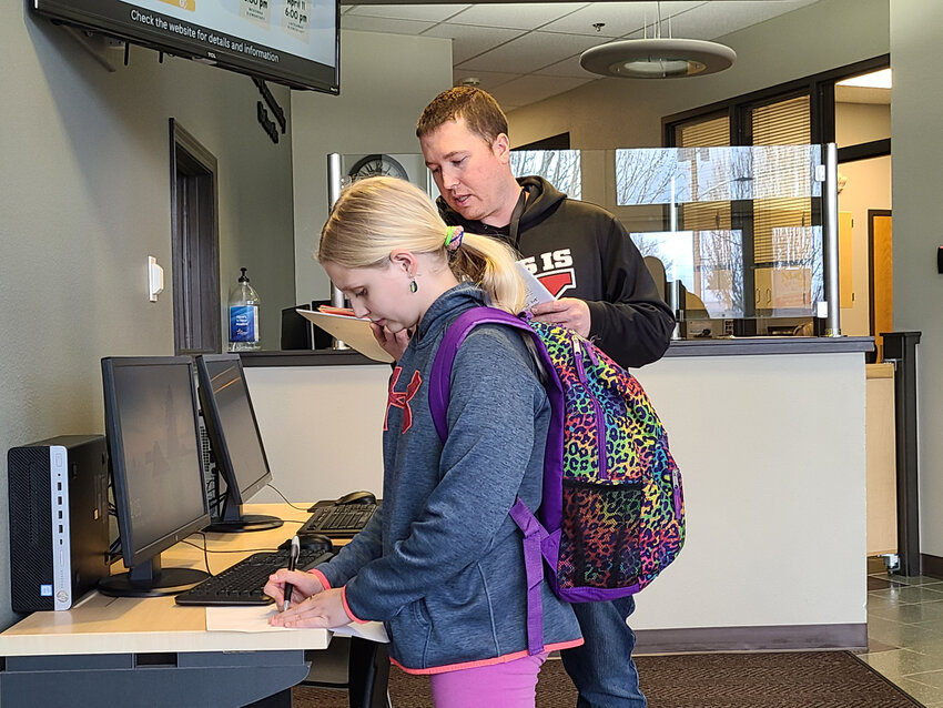 Mill Pond Elementary fifth grader Elizabeth Geszvain works on a math problem with Jordan Coleman at the Yelm Community Schools district office on March 27.