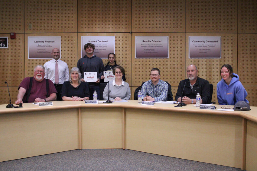 Jonah Smith and Madisyn Erickson pose with their certificates and the Yelm school board during a meeting on March 28.