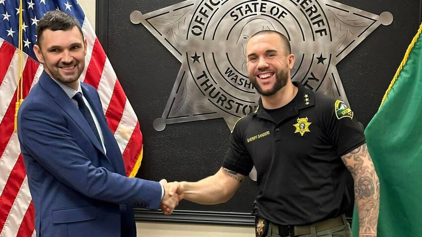 Thurston County Sheriff Derek Sanders, right, shakes Christopher Burbank's hand in this photo posted to the Sheriff's Office Facebook page. Burbank was one of three officers acquitted in December of the shooting death of Manny Ellis in 2020 in Tacoma. Burbank was hired as a lateral patrol deputy.