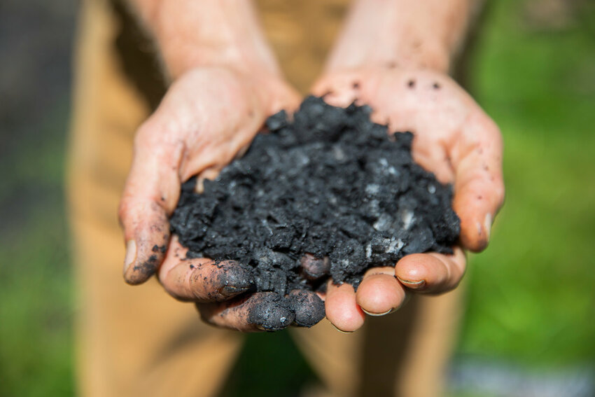 Brian Dennis holds biochar, a charcoal-like substance used as a soil amendment, in Toledo in 2022.