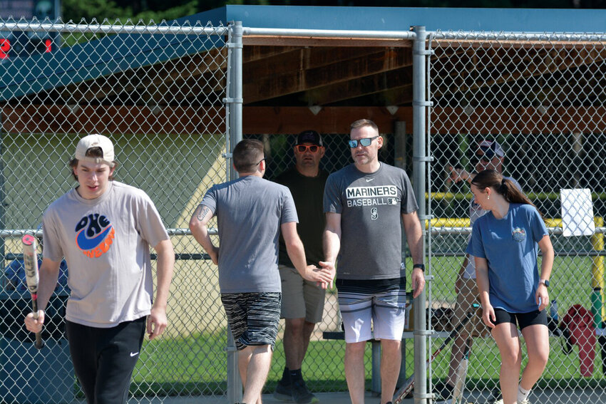 High fives are exchanged in last year’s charity mushball tournament at Longmire Park.