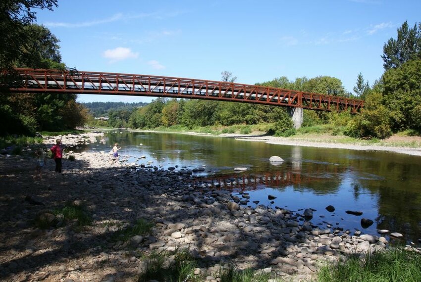 A long bridge crosses over the Washougal River at the Washougal River Greenway Trail in Camas, Washington.