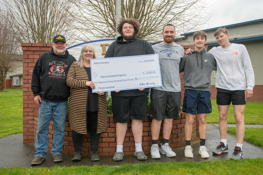 From left, Jim and Cindy Smith on Monday present members of the Adna football program &mdash; Ben Andrew, coach Tyler Shepherd, Jack Smith and Gavan Muller &mdash;&nbsp;with a check for $5,342.63, the total proceeds raised from the Adna Crab Feed fundraiser.