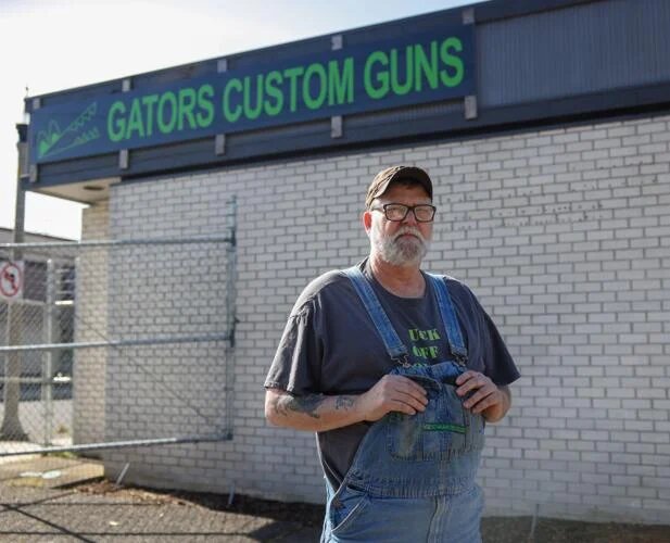Gator's Custom Guns Owner Wally Wentz poses for a portrait in front of his store on Wednesday, April 10 in Kelso.