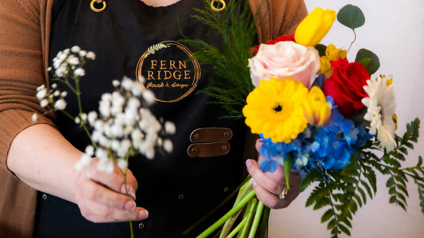 Owner Rebecca Williams organizes a bouquet inside Fern Ridge Floral &amp; Design in Centralia on Friday, April 21, 2023. The business will take part in a Centralia Downtown Association block party on April 24.