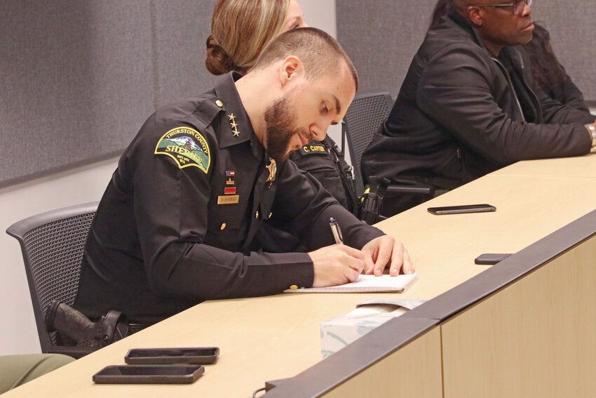 Thurston County Sheriff Derek Sanders takes notes during a public forum at the Atrium in Olympia on Thursday, April 11.