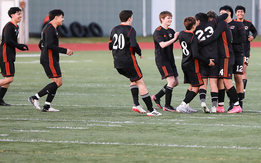 Members of Centralia's boys soccer team mob Samuel Carpio (23) after he scored a goal in the second half against Rochester in an Evergreen Conference match at Tiger Stadium on April 12.