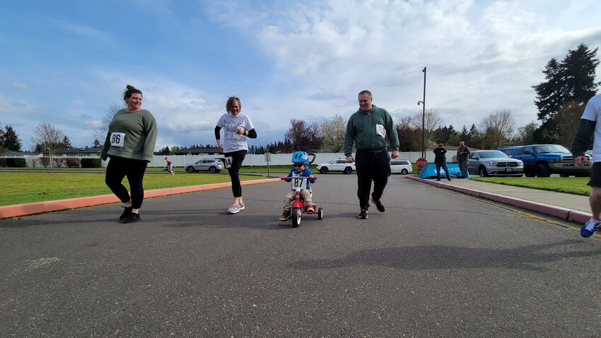 A young participant rides a tricycle in the 2022 Learners Without Limits 5K fundraiser.