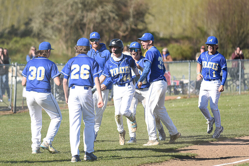The Pirates mob Cameron Nakano (44) after Nakano's walk-off double in Adna's win over Toutle Lake on April 17.
