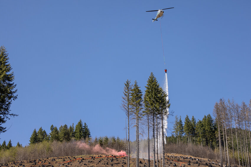 A helicopter drops water during the DNR aviation exercise in the Capitol State Forest on Wednesday, April 17.