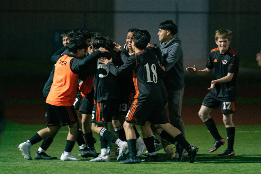 Tiger teammates celebrate around Damian Corona after his game winning overtime goal in Centralia&rsquo;s win over W.F. West on Friday, April 19.