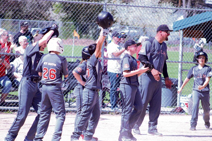Yelm's team celebrates after a grand slam during Nisqually Basin Youth Baseball's opening day on April 20.