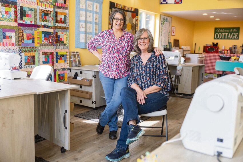 Cat Wallace, left, and Patti Ledesma pose for a photo in the Love Covers studio behind Ledesma&rsquo;s house on Thursday, April 11. Wallace and Ledesma started the nonprofit together in 2021 to bring people together through quilt making.
