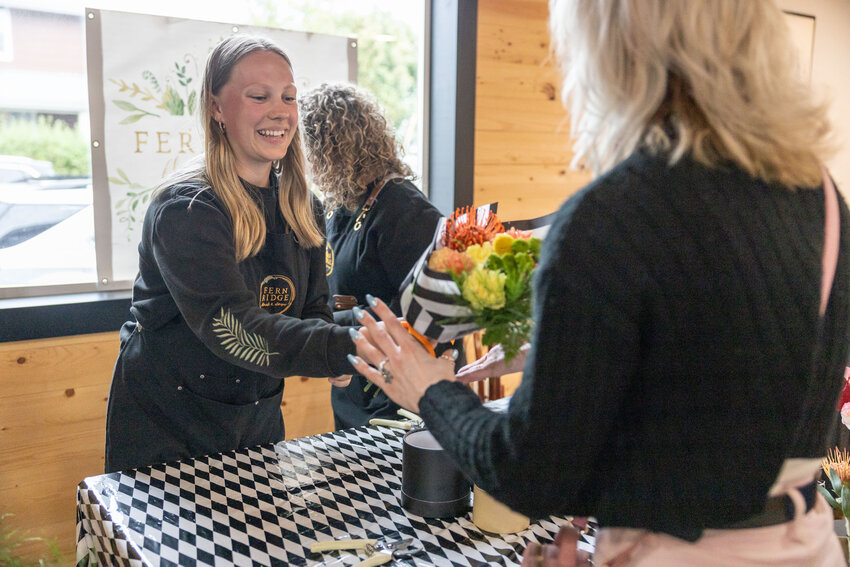 Natalie Humphrey, with Fern Ridge, hands a finished bouquet to an attendee during the Alice in Flowerland Tea Party at British Bites in Centralia on Wednesday, April 24.