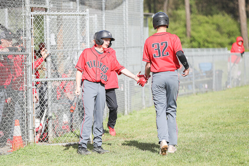 Mossyrock's Gunnar Callies (29) high-fives Hunter Isom after he scored a run during Mossyrock's win over Oakville on April 29.