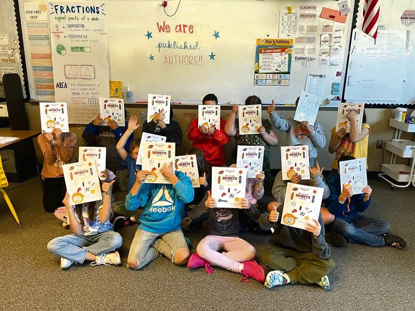 Taylor Ratkie's third grade students pose for a photo with their copy of &quot;The Lessons Sports Teach Us.&quot;
