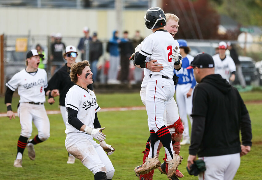 Tenino's Cody Strawn (2) is picked up by teammate Austin Gonia after Strawn hit a sacrifice fly to finish a 3-2 Evergreen League win over Elma on Tuesday night in Tenino.