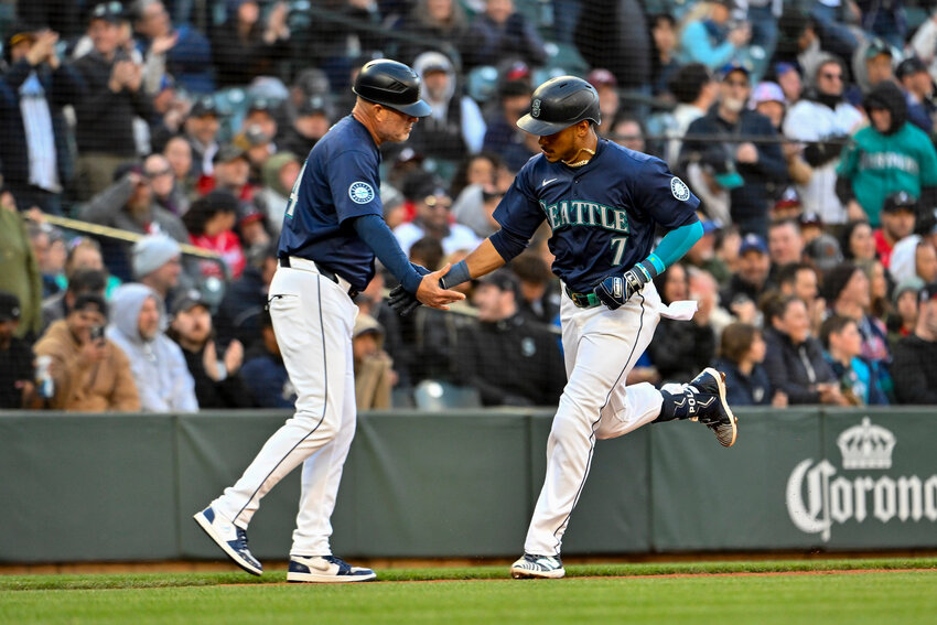 Jorge Polanco #7 of the Seattle Mariners celebrates his two-run home run with third base coach Manny Acta #14 in the third inning against the Atlanta Braves at T-Mobile Park on April 30, 2024 in Seattle, Washington. (Photo by Alika Jenner/Getty Images/TNS)