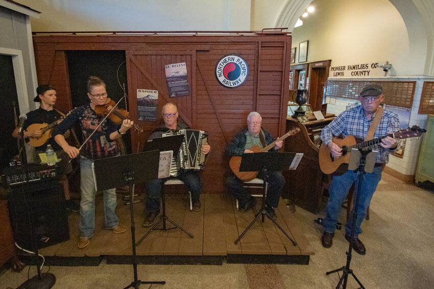 From the left, Washington Old Time Fiddlers Association members Kain Wallen, Christie Easter, Mike Turner, Flenn Palmer and Rick Sundstrom perform inside the Lewis County Historical Museum for a Lewis County Historical Society meeting on Tuesday, March 19, in Chehalis.