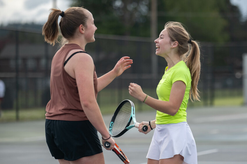 W.F. West's Lilly Hueffed and Katelyn Wood smile after scoring a point during a girls tennis match between W.F. West and Centralia at Centralia High School on Wednesday, May 1.