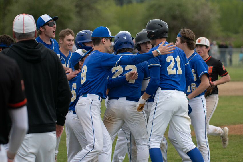 Pirate teammates storm Owen Fagernes after his walkoff hit during Adna&rsquo;s district quarterfinal win over Kalama at Adna High School on Friday, May 3.