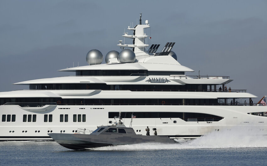 A Navy boat speeds by the $300 million dollar, 348-foot luxury yacht Amadea, belonging to Suleiman Kerimov, a sanctioned Oligarch and beneficiary of Russian corruption as it sailed into San Diego Bay on Monday, June 27, 2022 in San Diego, CA. The United States announced the seizure in Fiji of the ship in May.