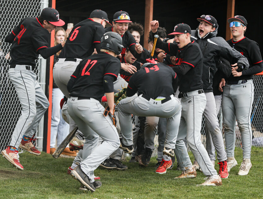 Members of the Toledo baseball team mob Gavin Frewing (19) after a solo home run against Pe Ell/Willapa Valley during a Class 2B District 4 loser-out game on Tueasday at Napavine High School.