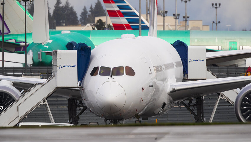 A new Boeing 787 Dreamliner, is seen between the main runway and the Boeing Delivery Center at Paine Field in Everett Washington on Tuesday December 15, 2020. Paine Field is across the street from the Boeing Factory where the 787 is assembled. The green colored planes in the background are 777's.