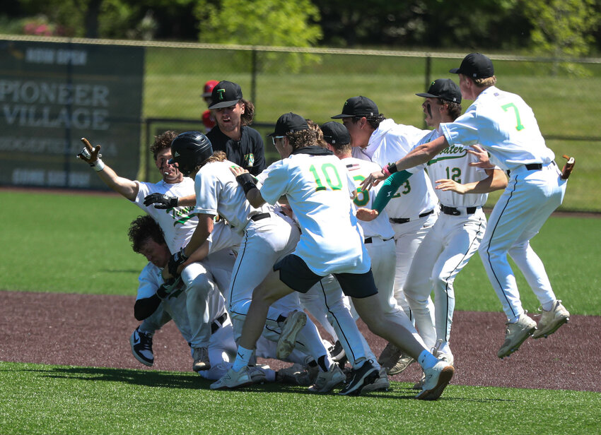 Members of the Tumwater baseball team mob Eddie Marson (gloved) after beating R.A. Long in a Class 2A District 4 loser-out game 3-2 to return to the state tournament on Saturday at the Ridgefield Outdoor Recreation Complex.