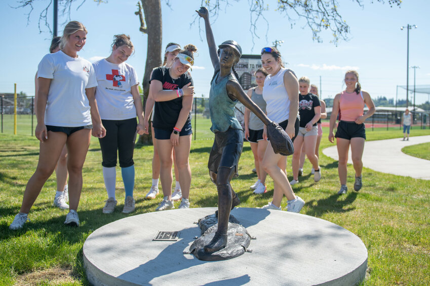 The W.F. West High School fastpitch team admires a new statue dedicated to the program as it is unveiled at Recreation Park on Friday, May 10.